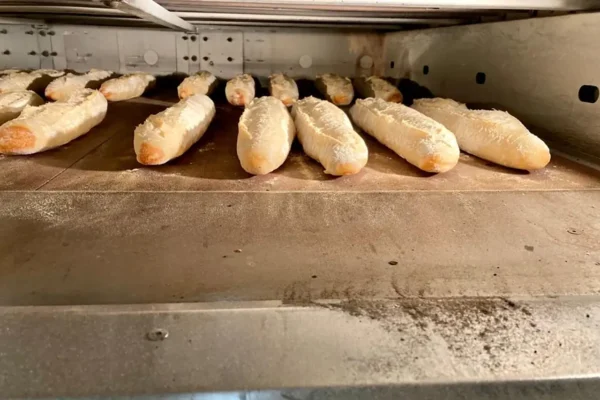 Baguettes de pain en cours de cuisson dans le fournil de la boulangerie pâtisserie la Talemelerie