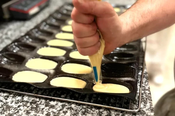 Moulage de madeleines à l’aide d’une douille à la boulangerie pâtisserie La Talemelerie à Grenoble et Chambéry